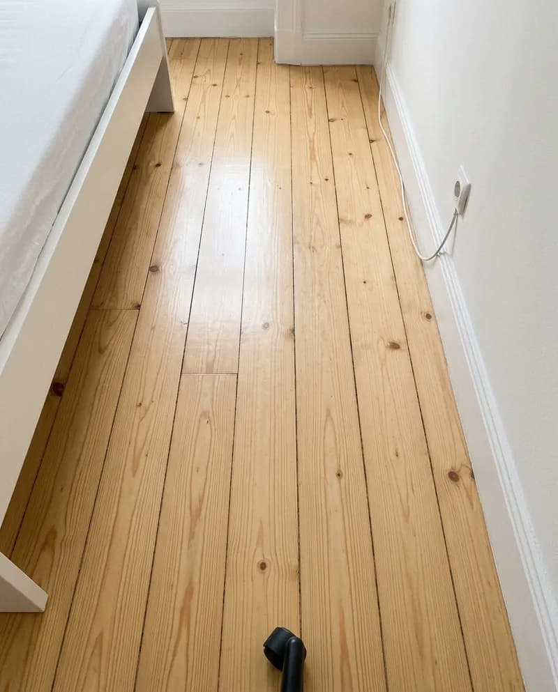 Um chão de madeira de um quarto, primeiro com manchas de sujidade, depois limpo